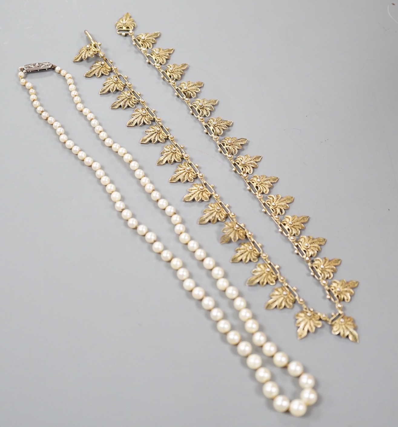 A single strand graduated cultured pearl necklace, with 925 clasp, 21cm and a gilt white metal filigree necklace.